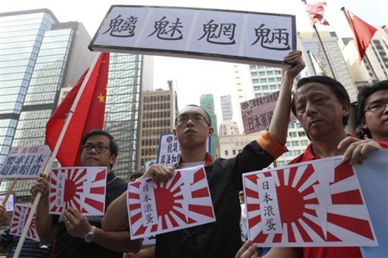 Anti-Japan protesters hold flags of the Japanese Imperial Army with "Japan get out" written on them during a demonstration in Hong Kong on Sunday.